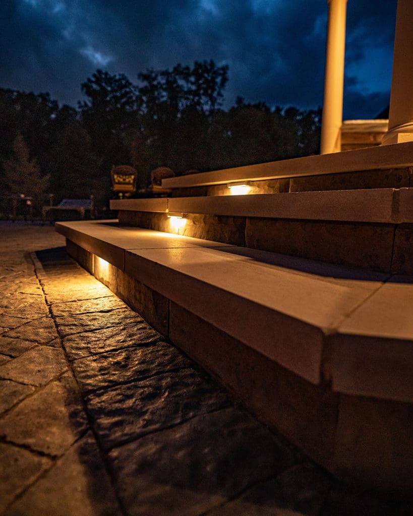 Dramatic outdoor patio with multiple stone fire pits and built-in grill in Westlake, Ohio