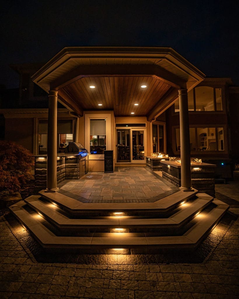 Dramatic outdoor patio with multiple stone fire pits and built-in grill in Westlake, Ohio