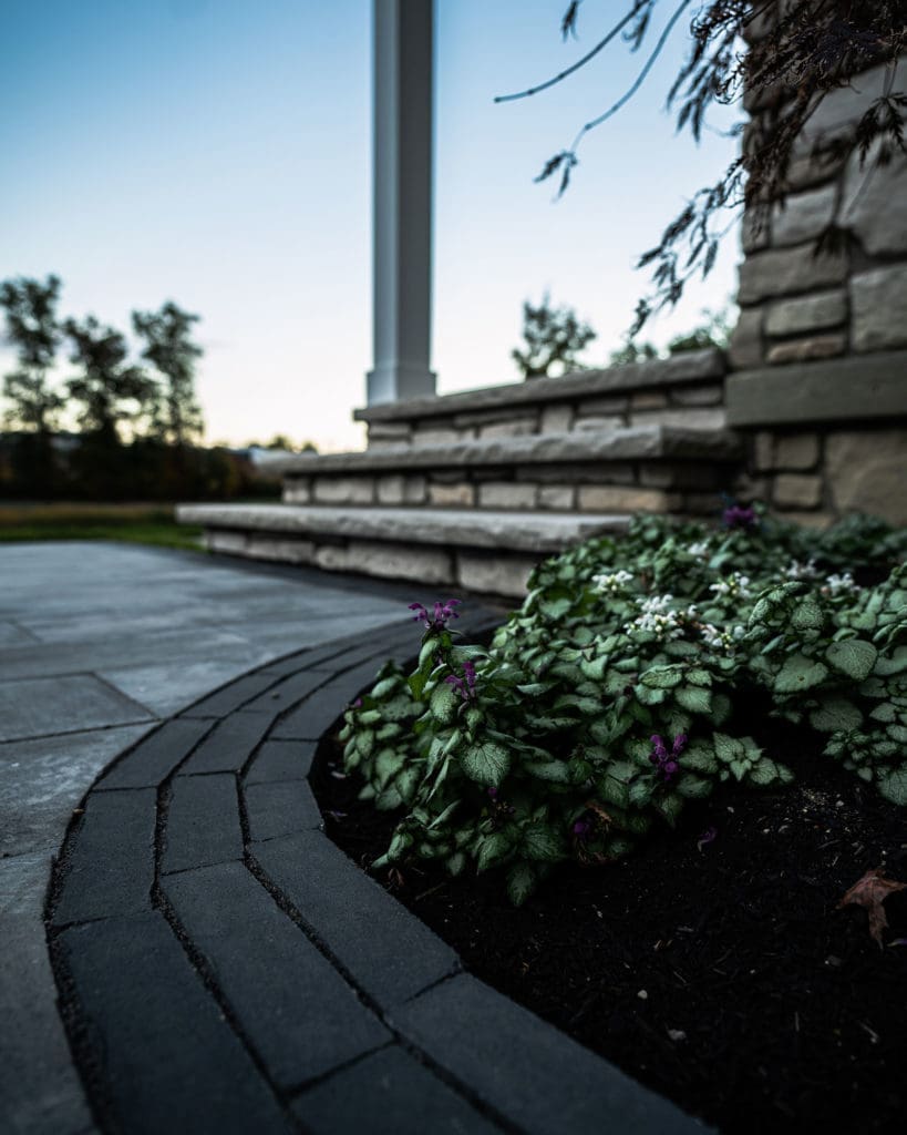Custom patio with stone steps and landscape designed and installed by Ground Works in Westlake, Ohio